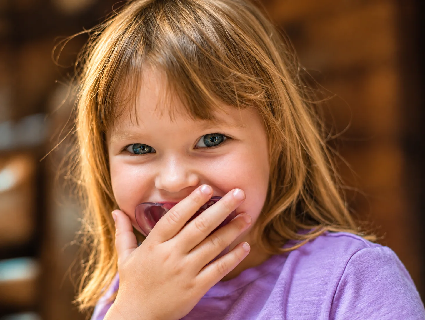Candid photographic portrait of a laughing child.