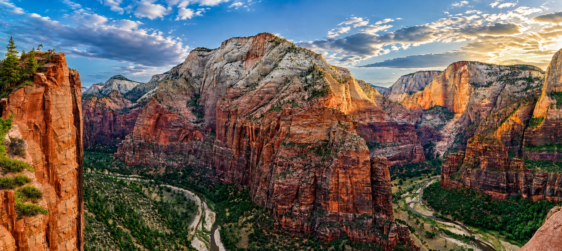 Vast sandstone cliffs and canyon country at golden hour.